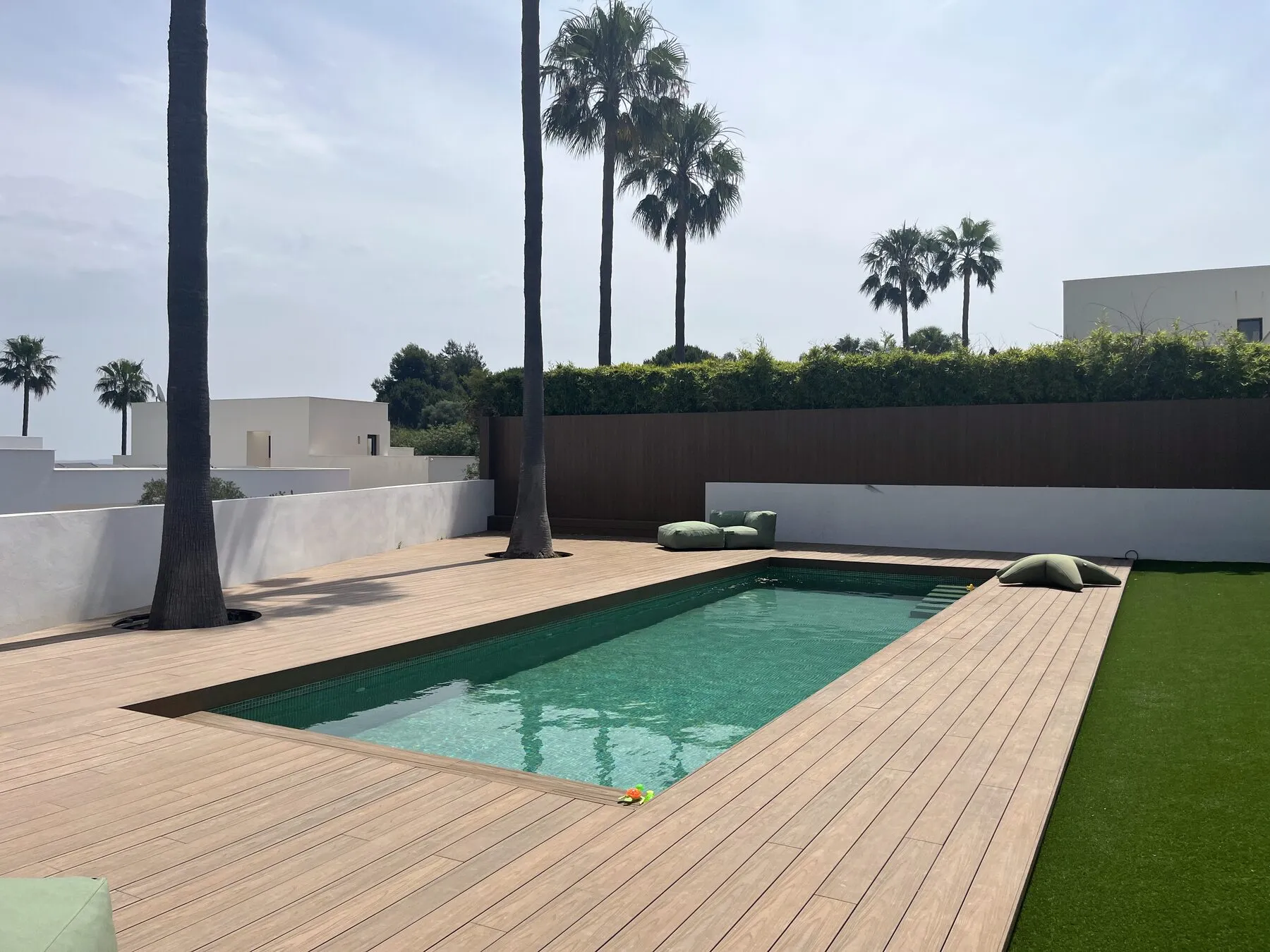 Completed pale Millboard deck surrounding a swimming pool in Marbella