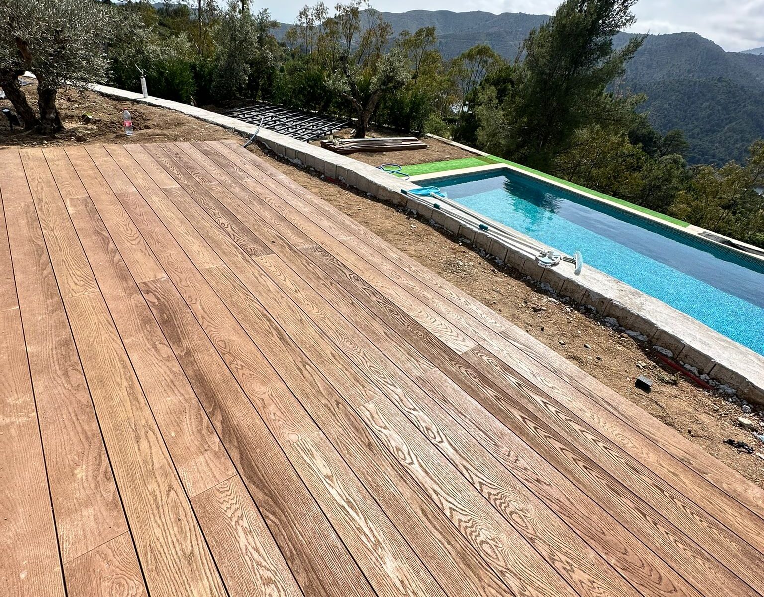 Millboard Coppered Oak terrace beside a pool with mountain views in Istán
